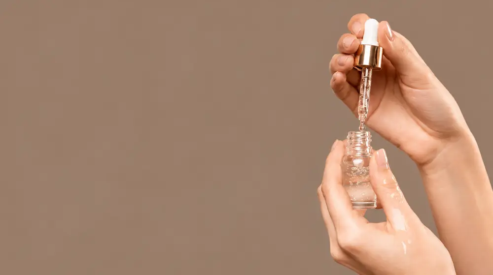 Hands holding a serum dropper